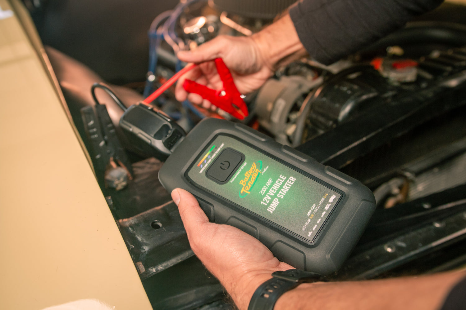 A man hooks his Battery Tender® jump starter to his vehicle's battery.